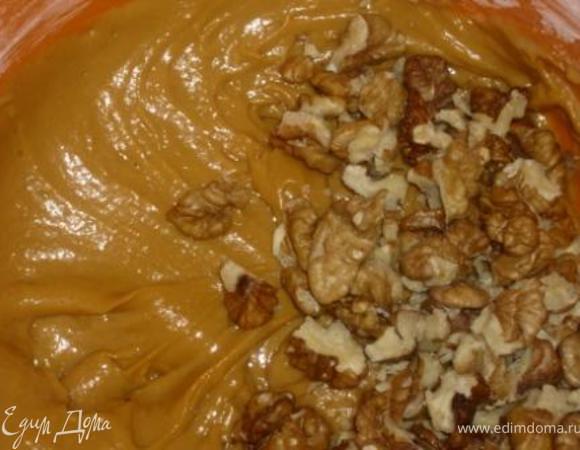 Быстро ввести, просеянную вместе с разрыхлителем и ванилином, муку.  Добавить в тесто крупно порезанные орехи (отложить несколько ядер для украшения).  