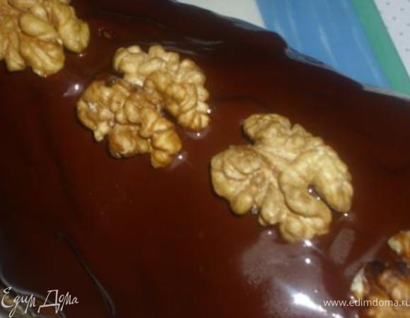 Готовый (не горячий) кекс покрыть глазурью и украсить орехами.