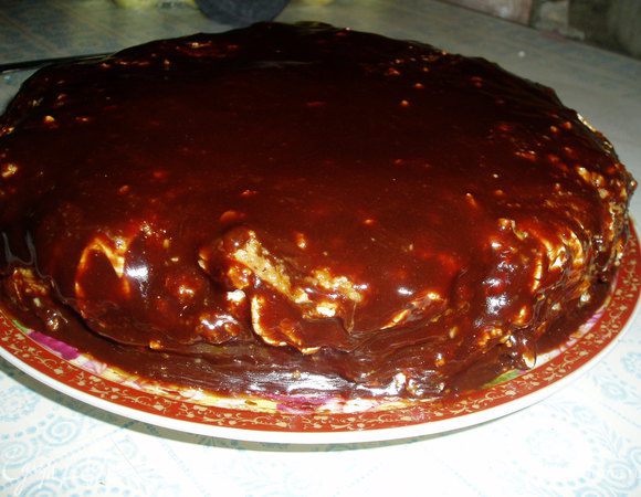 Готовим глазурь. В кастрюльке смешиваем все ингредиенты, ставим на водяную баню, доводим до кипения. Немного охлаждаем глазурь и покрываем ею торт.