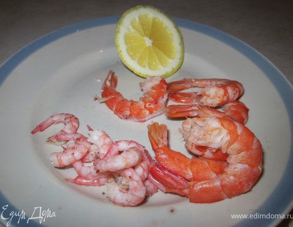 Очищенные креветки сбрызнуть лимонным соком. Обжарить на отдельной сковороде с чесноком две минуты.
