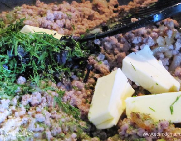 Добавьте перекрученную через мясорубку говядину, зелень, соль, перец, кусочки сливочного масла.