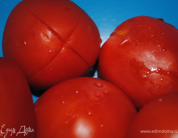 На помидорах сделать надрезы, ошпарить кипятком, через две минуты опустить в холодную воду и снять кожуру, измельчить.