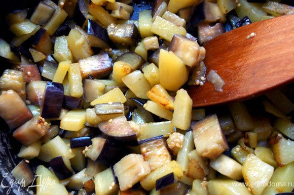Картофель очистить, нарезать, обсушить и обжарить в глубокой сковороде, с добавлением масла, 2-3 минуты. Добавить кусочки баклажана и продолжать готовить до мягкости овощей либо до состояния, которое Вам по душе.