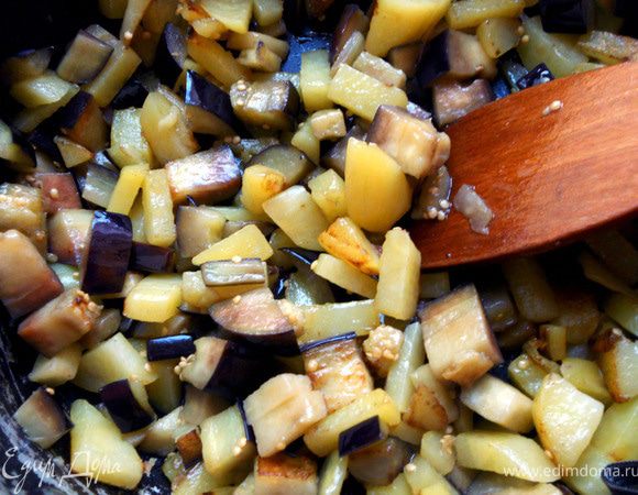 Картофель очистить, нарезать, обсушить и обжарить в глубокой сковороде, с добавлением масла, 2-3 минуты. Добавить кусочки баклажана и продолжать готовить до мягкости овощей либо до состояния, которое Вам по душе. 