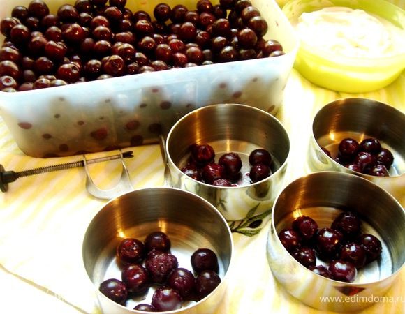 Если десерт не будет подаваться в формочках для запекания, то тогда формы следует хорошо смазать сливочным маслом и выложить в них подготовленную вишню и шоколад.