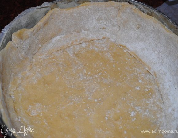 Обе части тонко раскатать на столе. Одну половину выложить на дно формы , а другой сделать " бортики", как на фото.