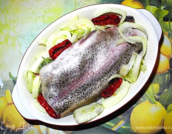 Порежем лимон кусочками и фенхель кружочками. Если хотите, можно рыбку оставить целой. Я отрезала для супа голову и хвост. Пузико нафаршировать лимоном, фенхелем и травами, положить форель в форму, оставшийся фенхель положить рядом. Добавить сушеные помидорчики (для цветовой гаммы). Сверху присыпать крупной солью немного.