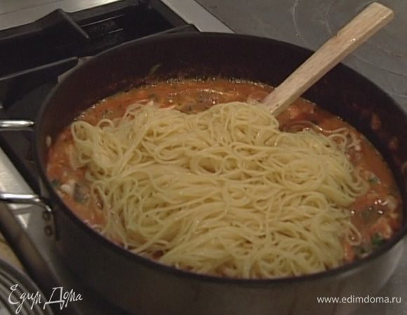 Спагетти отварить в подсоленной воде и откинуть на дуршлаг, затем выложить в сковороду к соусу и все перемешать.