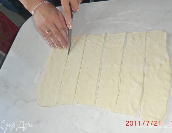 Тесто разморозить. Затем немного раскатать в одном направлении на смазанном маслом столе.
Нарезать на полоски шириной 2-5 см.