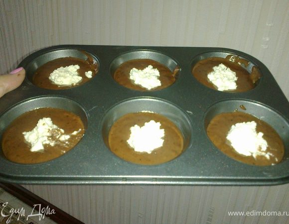 В смазанные маслом формочки выложить на 1/3 тесто, а в серединку выложить начинку из творога.