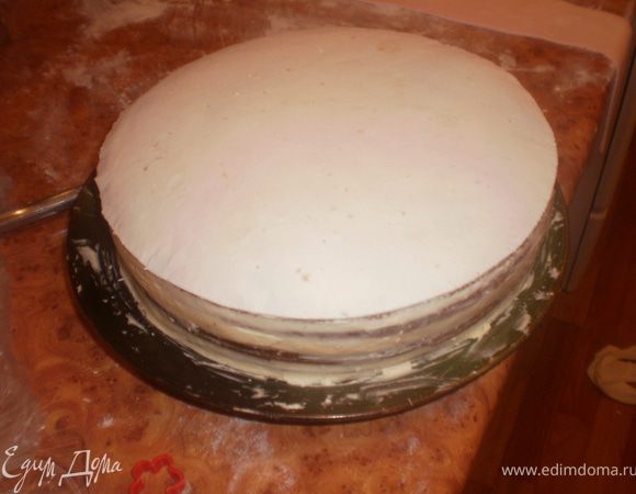 Из белой мастики вырезаем круг по диаметру торта. Покрываем торт сверху.