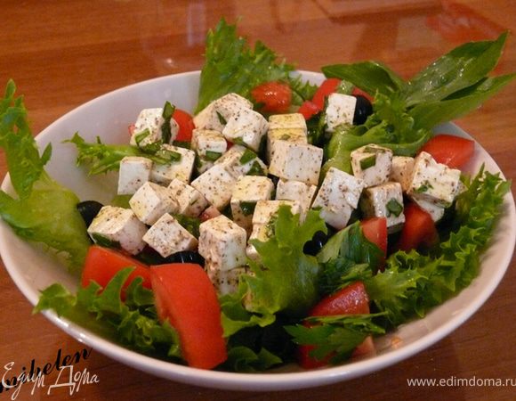 Крупно нарезаем помидоры, перец, маслины нарезаем на три части, листья салата руками разрываем на крупные куски. Далее добавляем сыр фета, который уже пропитался пряностями и оливковым маслом, больше масла добавлять не нужно. Посолить по вкусу. Украсить листиками базилика