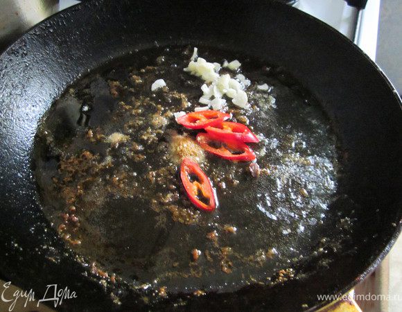 На той же сковородке, где жарились окорочка обжариваем чеснок, имбирь и перец.