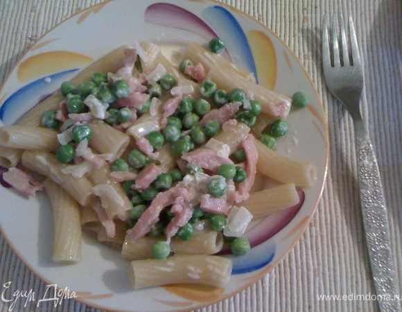 На сковороде разогреть сливочное масло (я добавляла еще оливкового). Чеснок раздавить ножом и обжарить в масле. Когда будет коричневый вытащить. Обжарить лук до прозрачности, добавить ветчину. Обжарить. Залить всё сливками – потушить пару минут. Добавить горошек, посолить, поперчить. Дать настояться на медленном огне.
В этот соус добавить заранее отваренные макароны, смешанные с оливковым маслом. Хорошо перемешать. Посыпать тертым пармезаном. 
Приятного аппетита.
