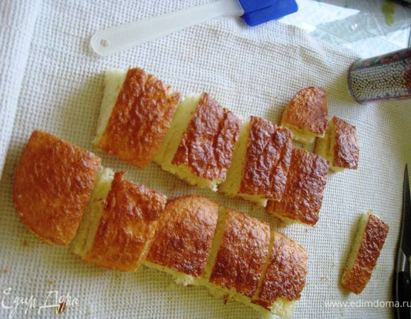 Отделить желтки от белков и растереть их с сахаром до бела.Затем добавить муку,соль и соду.Аккуратно ввести заранее взбитые в пену белки.Выпечь бисквит.Разрезать его на 2 части и на кубики.