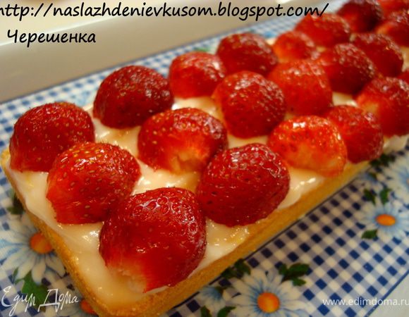 Теперь собираем наш десерт в единое целое. Каждый корж промазываем полученным кремом и покрываем слоем из клубники, разрезанной пополам…