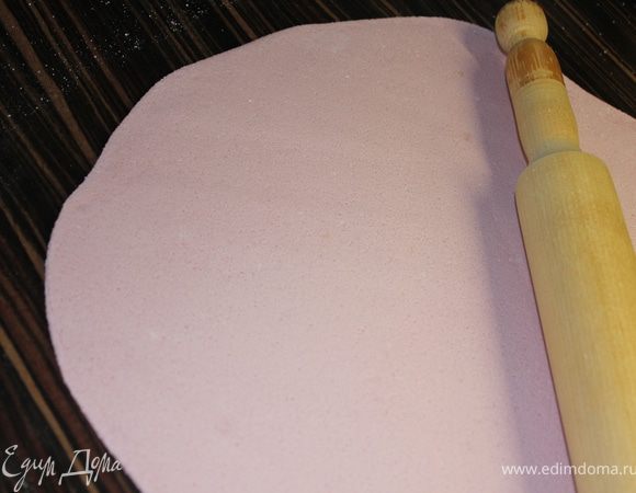 Раскатать сиреневую мастику и накрыть ею нижний ярус. Края  подровнять (отрезать лишнее).