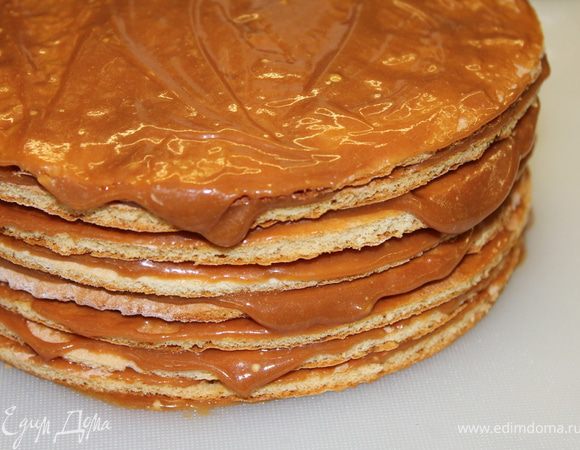 Промазать коржи для верхнего яруса. Верх и бока соответственно промазать...Раскатать белую мастику и накрыть ею этот ярус.Лишнее отрезать.