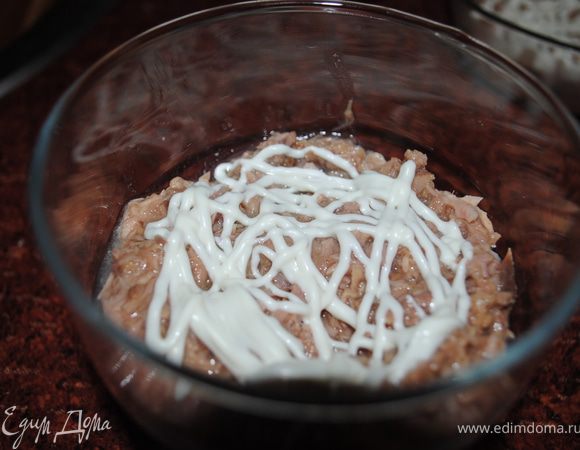 На дно салатницы выложить ложку порубленного тунца, сверху сеточку с майонеза