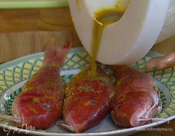 Рыбу выпотрошить (голову оставить) и часто наколоть зубочисткой или пищевой иглой. Смазать снаружи и изнутри апельсиновым соусом и оставить мариноваться на 20−30 минут.