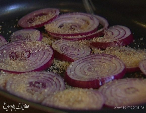 Лук почистить, нарезать кольцами и выложить в один слой в небольшой противень. Посыпать сахаром, посолить, сбрызнуть бальзамическим уксусом и отправить под гриль на 10−15 минут.