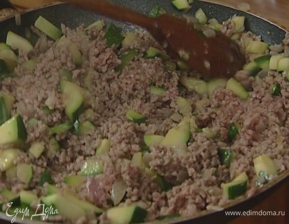Цукини нарезать кубиками и добавить к луку и чесноку, а спустя 2–3 минуты отправить туда же фарш и, постоянно помешивая, жарить все 5 минут.