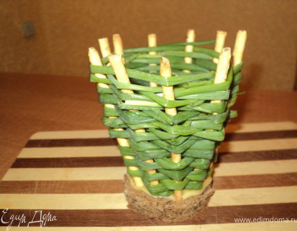 Подготовить корзинки ( 2шт ): из кусочков хлеба и пластинок сыра вырезать круги диаметром 7см. На кружок хлеба положить кружок сыра ( чтобы хлеб не размок от салата), воткнуть по по кругу соломку и оплести перышками лука.