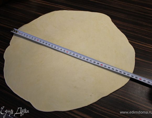 Достать тесто из холодильника. Раскатать его в круг диаметром около 38 см, посыпав стол и тесто небольшим количеством муки. На противень положить пергаментную бумагу, посыпать чуть мукой и переложить тесто с помощью скалки.<br />
На самом деле тесто настолько комфортное, что это делается очень легко и приятно:)