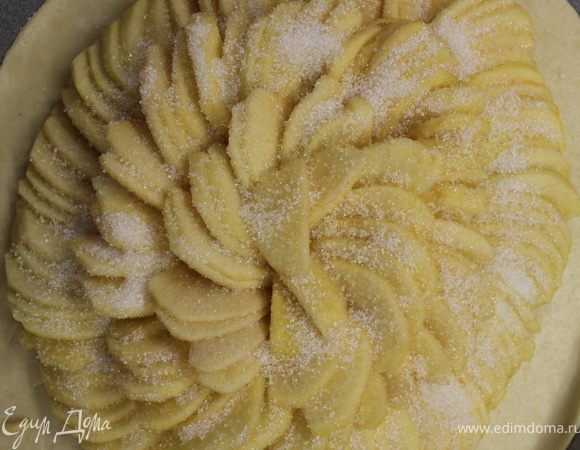 Уложить дольки яблок по кругу, оставив от края 4 см на бордюр.