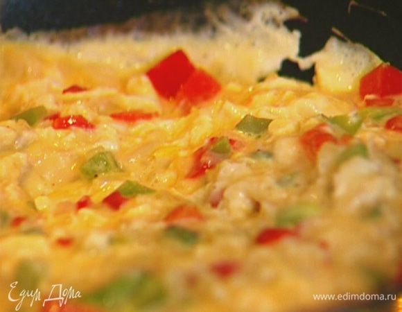 Вылить яичную массу в сковороду с луком и перцем. Постоянно помешивая, обжаривать омлет до готовности. 