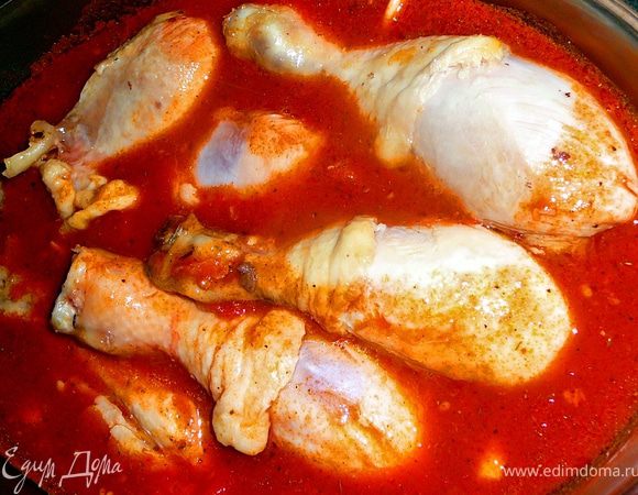 В керамической,жаропрочной кастрюле растопить сливочное масло,добавить оливковое.Можно это сделать и на обычной сковороде,а потом перелить в жаропрочную посуду.Выложить обмытые и обсушенные голени(бедра),обжарить до легкой золотистой корочки со всех сторон.Примерно по 2 минуты на одну сторону.Голени достать.Влить в масло вино,протушить около минуты.Добавить порезанные томаты,томатный сок,томатную пасту,соль,перец,перемешать.Довести соус до кипения.Выключить.Влить бульон,положить чеснок(чеснок не резать,не давить через пресс,а просто раздавить ножом и так положить),добавить мелко порезанные травы или же как сделала я, сухие травы размолола с ступе.Вернуть куриную голень (бедра),накрыть крышкой и поставить в разогретую до 200 градусов духовку на 50-55минут.Очень хорошо эта курица подойдет к пасте или макаронам. 
