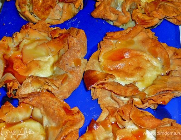 Берем формочки для кексов,смазываем сливочным маслом.Лист теста нарезаем на квадраты(у меня ушло 3 листа,на 7 формочек).Теперь у нас маленькие листы теста.Смазываем первый маленкий лист сливочным мягким маслом,ложим его в формочку(я делала чтоб края свисали и специально делала их неровными,а как бы смятыми,для того чтоб потом после запекания в получившиеся от смятия промежутки влить сироп или мед).Берем второй м.лист так же смазываем маслом и присыпаем сахарной пудрой смешанной с корицей и молотыми орехами,ложим сверху на первый лист.Берем третий м.лист смазываем маслом и накрываем им второй.Теперь можно положить начинку.Если вы хотите сделать начинку как у меня(начинка из отвешенной сметаны),то сметану отвесить на ночь в марле,затем добавить в нее сахарную пудру,одно яйцо и взбить,добавить крахмал.На 7 формочек у меня ушло около 150гр.сметаны отвешенной,пудра по вкусу и 1,5ч.л.крахмала.Если вы решили добавлять начинку в корзиночки уже после выпечки,то я бы посоветовала насыпать в корзинки сухого гороха,для поддержания формы.Выпекать в разогретой духовке до 180гр.,около 30 минут.Достать корзинки,выложить из них горох и еще горячими полить медом,стараясь наливать мед в промежутки между листами. 
