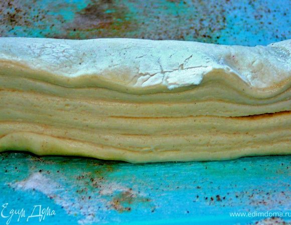 Тесто разморозить.Сложить в несколько слоев.Отрезать полоску по ширине около 4 см.Доску присыпать сахарной пудрой и корицей,полжить на нее тесто. 
