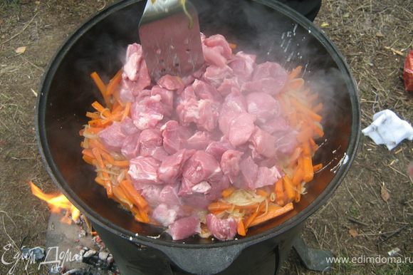Добавьте мясо к овощам. Готовьте на сильном огне, пока мясо не начнет слегка подрумяниваться. Длительность этого этапа зависит от вида мяса, которое вы используете. Если вы готовите плов с говядиной, нужно тушить дольше.