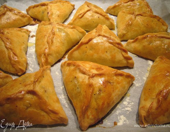 Выложить начинку (чуть больше столовой ложки), соединить края треугольником. Выложить пирожки на лист пергамента, посыпанный мукой, смазать яйцом, поставить в разогретую духовку при 180-190 гр. на 40 мин до румянца.
