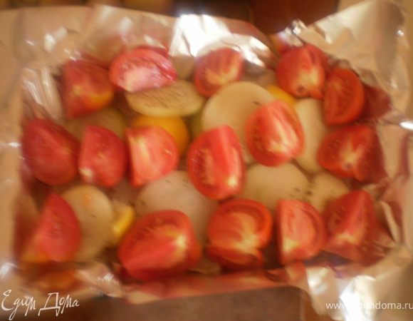 На фольгу выложить лук и кусочки помидоров.