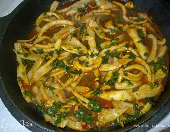 В соус добавить мелко нарезанные листья кинзы и петрушки, и выложить в соус кальмары. Дать закипеть, перемешать и сразу же подавать.