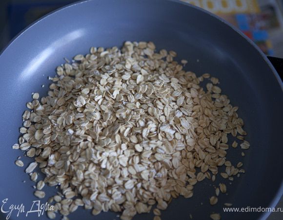 поставить сковороду на слабый огонь, всыпать овсяные хлопья