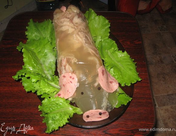 Приготовить заливное по любимому рецепту. Добавить разведенного по инструкции желатина (чтобы наверняка хорошо застыло). В пластиковую литровую бутылку налить заливное, после застывания аккуратно разрезать ножом, вытянуть заливное, положить на блюдо с зеленью. Из колбасы сделать ушки, пятачок, хвостик.