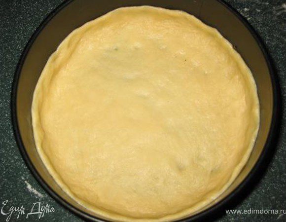 Приготовить форму диаметром около 22см (лучше разъемную или силиконовую). Распределить руками тесто в форме, присыпая его мукой, чтобы оно не прилипало к пальцам. Сделать небольшие бортики.