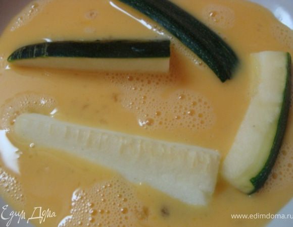 Разбиваем два яйца в емкость и окунаем каждую палочку...