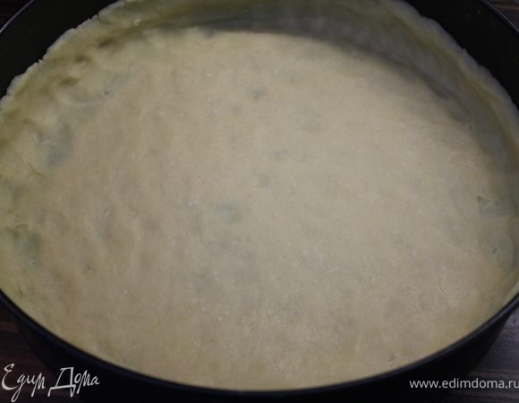 Тесто достать из холодильника. Раскатать диаметром 34 см, немного присыпав скалку и стол мукой. В разъемную форму (d 28 см) выложить тесто и сделать бортики высотой 3 см. Накрыть фольгой, выложить на нее фасоль или невареный рис и выпекать 15 минут. Удалить фольгу с фасолью и выпекать еще 5-10 минут, пока тесто не зарумянится... Вынуть тесто и убавить температуру до 190 градусов.