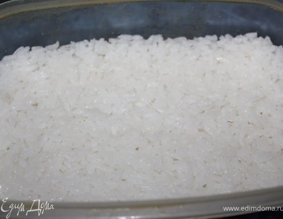 Отварной рис откинуть на дуршлаг, промыть под холодной водой и дать стечь воде. Выложить рис в емкость глубокую. 