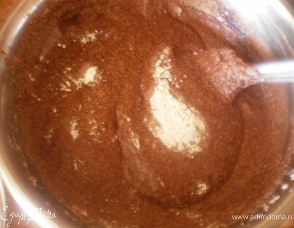 К шоколадным белкам по ложке всыпать просеянную муку с разрыхлителем.
