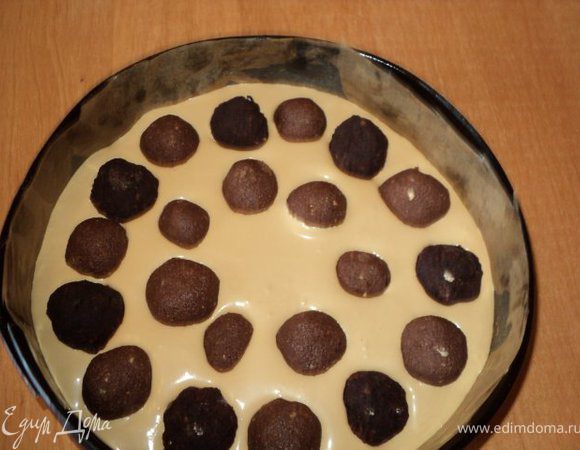 Половину кофейного крема выложить на основу, разложить начинку - шарики.