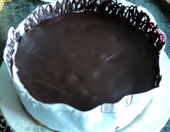 Для украшения растопить в микроволновке или на водяной бане поломанную на кусочки плитку шоколада, выложить растопленный шоколад в полиэтиленовый пакетик, срезать кончик уголка и выдавливая,  нанести на полоску из бумаги для выпечки или плотного полиэтилена ( по длине окружности торта и высотой 7-8см) зигзагообразные линии. Дать шоколаду немного схватиться и обернуть лентой торт. Поставить в холодильник до полного застывания шоколада.