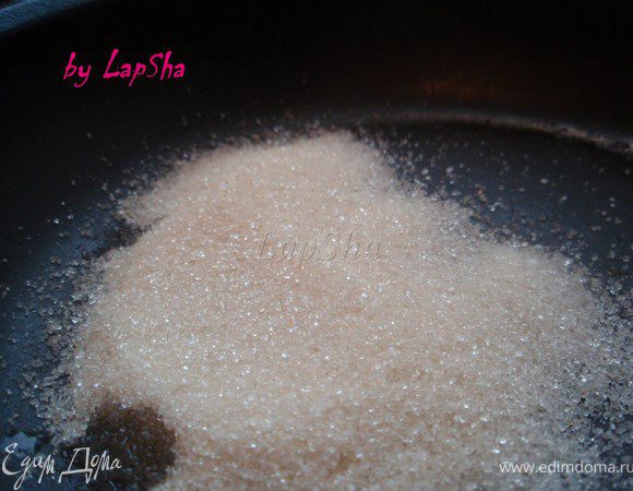 В разогретый сотейник или сковороду высыпать сахар и добавить воду.