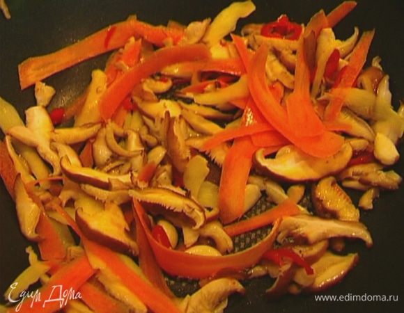 Разогреть в воке оливковое масло и обжаривать грибы, морковь, имбирь и чеснок в течение 2 минут. 