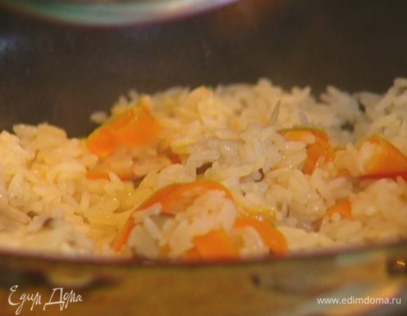 Всыпать рис, перемешать и залить горячим куриным бульоном так, чтобы рис был покрыт жидкостью на два пальца. Закрыть крышкой и готовить 15–20 минут. 