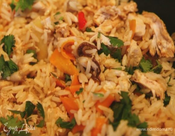 Когда рис будет готов, добавить курицу и 2/3 нарубленной кинзы, влить соевый соус, перемешать и посыпать оставшейся кинзой.